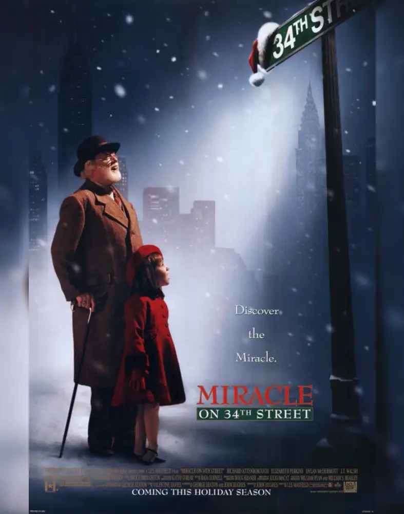 A man and girl stand under a streetlight on a snowy night.
