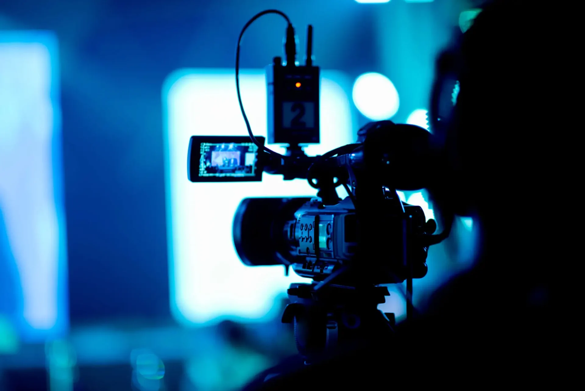 Professional video camera set up for recording in a dimly lit environment.